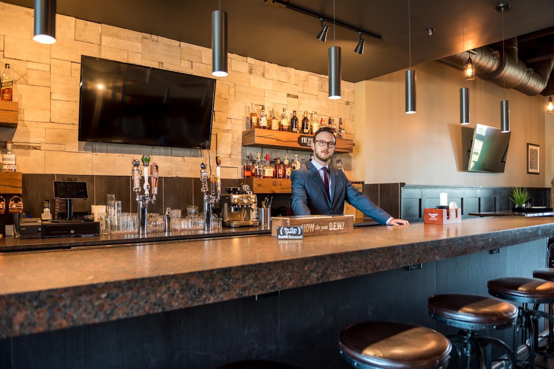 The full bar with taps and premium liquors at Scissors & Scotch Uptown Charlotte