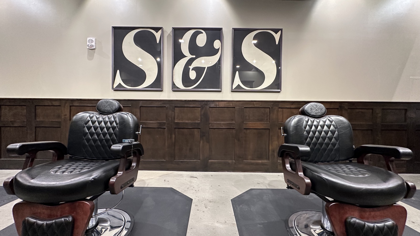 The barber-chair floor at Scissors & Scotch Uptown Charlotte, with the S&S wall art
