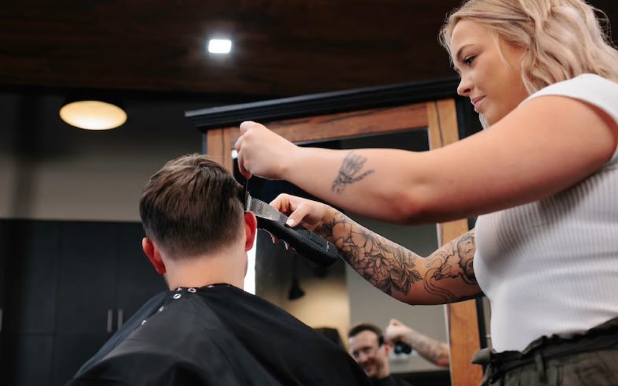 A stylist working on a client's hair at Scissors & Scotch Uptown Charlotte