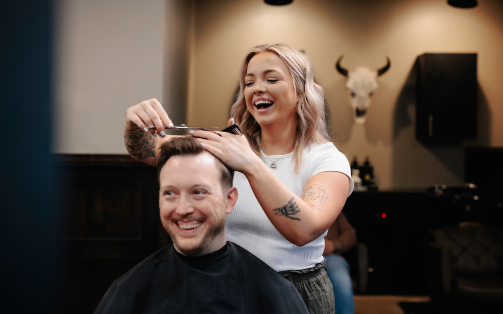 A stylist giving a haircut at Scissors & Scotch Uptown Charlotte