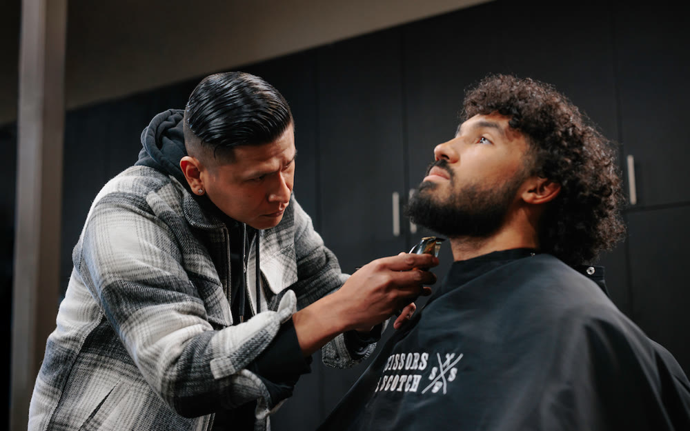 A barber detailing a beard at Scissors & Scotch Uptown Charlotte